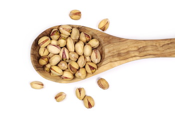 Pistachios in wooden spoon isolated on white background, top view