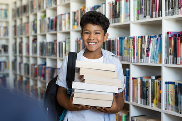 Wall Mural - Elementary school boy holding books