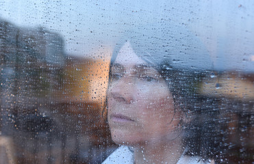 Woman looking out the window on a rainy day