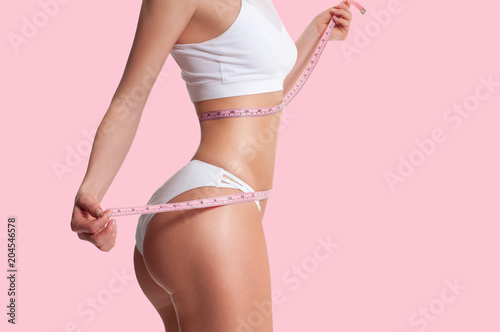 Fotomural Woman measuring her sporty body, successful weight loss