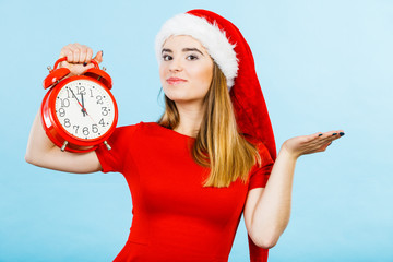 Woman wearing Santa Claus costume holding clock