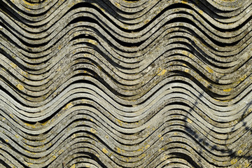 Corrugated slate lies in a pile, side view background texture of slate