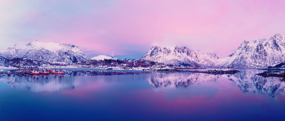 Landscape with beautiful winter lake and snowy mountains at sunset at Lofoten Islands in Northern Norway. Panoramic view