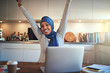 Young Arabic woman ecstatically celebrating her business success