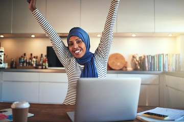 Wall Mural - Young Arabic woman ecstatically celebrating her business success