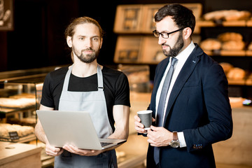 Wall Mural - Businessman and barista working in the pastry shop