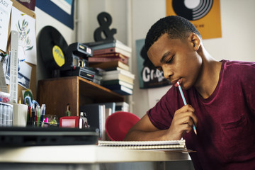 Wall Mural - Teenage boy in a bedroom doing work thinking