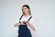 © Вячеслав Чичаев - Portrait of a beautiful girl on a white background showing a heart with her hands