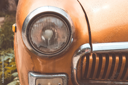 Láminas Headlight on an old car. Vintage toned.