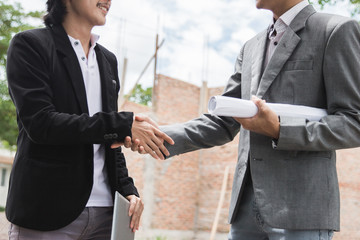 designers discussing construction plan shaking hand