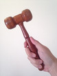 Judge hammer and a right hand holding the hammer with white isolated background