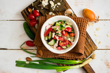 Fresh vegetables Greek salad with tomatoes, cucumbers, onion slices and sprouts. Served with olive oil. Raw vegan vegetarian healthy food on lunch or dinner