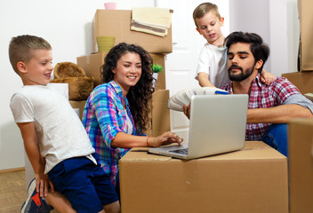 Wall Mural - Happy young family moving into their new home. They sitting on the floor and choosing colors for the walls.