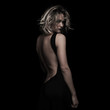 © Viorel Sima - side view of beautiful blonde woman wearing black backless dress