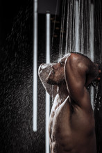 Muscular Man With Raised Hands Enjoying Having Contrast Shower. Calm Tension