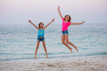 Two young girls doing gymnastic at the beach