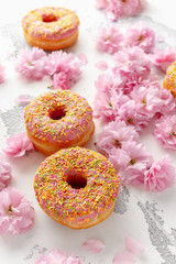 Wall Mural - Sweet pink fresh Donut decorated with japanese Flowering Cherry Tree flower