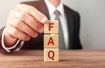 Poster - Businessman made word FAQ with wood building blocks.