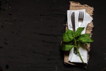 Rustic vintage set of knife and fork on a napkin (cutlery). Black background. Top view