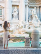 Woman in white dress  in front of Trevi Fountain in Rome