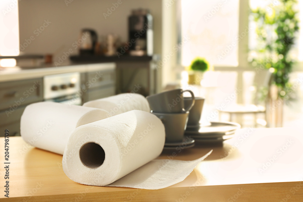 Rolls of paper towels and dishware on table indoors