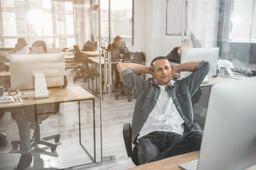 Poster - Portrait of cheerful male resting while situating at desk. He looking at computer screen