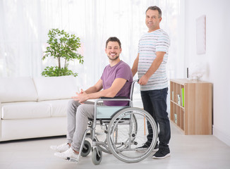 Canvas Print - Mature man and his son in wheelchair indoors