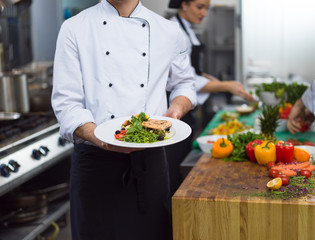 Wall Mural - Chef holding dish of fried Salmon fish fillet