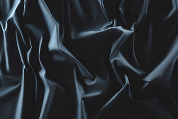 close up view of crumpled dark blue silk fabric as background