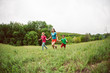 © zhukovvvlad - A woman with children runs along the grass.