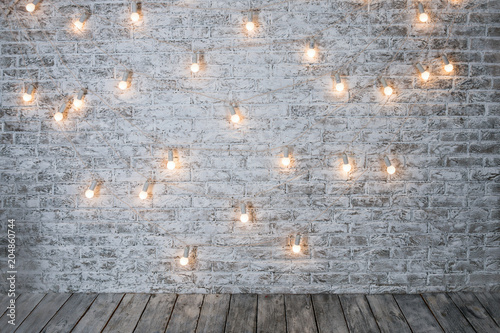 Light Bulbs On White Brick Background With Wooden Floor