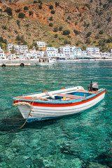 Wall Mural - Fishing boat and the scenic village of Loutro in Crete, Greece