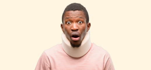 Wall Mural - Injured african black man wearing neck brace scared in shock, expressing panic and fear