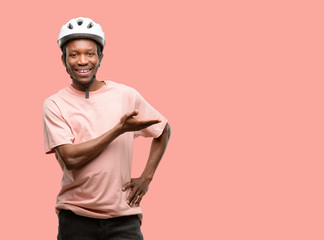 Poster - Black man wearing bike helmet holding something in empty hand