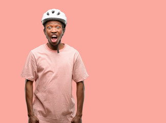 Poster - Black man wearing bike helmet stressful, terrified in panic, shouting exasperated and frustrated. Unpleasant gesture. Annoying work drives me crazy