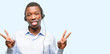 © Krakenimages.com - Black man consultant of call center looking at camera showing tong and making victory sign with fingers