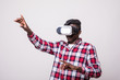 © dianagrytsku - young happy and excited afro american man pointed button wearing virtual reality vr 360 vision goggles enjoying video game isolated on whitebackground in innovation and gaming technology concept