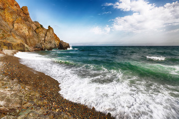 Wall Mural - Sea waves crashing on the shore and flowing above seashore pebbles