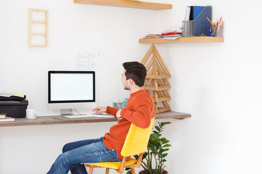 Team of young creative designers - young girl illustrator and guy designer discussing a new project in the office with computer with a white screen. Space for text