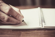 © Siriporn - close up of a hand holding pen on white notebook