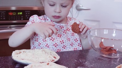 Canvas Print - Little girl making home made small pepperoni pizzas