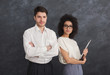 Confident business couple on gray background