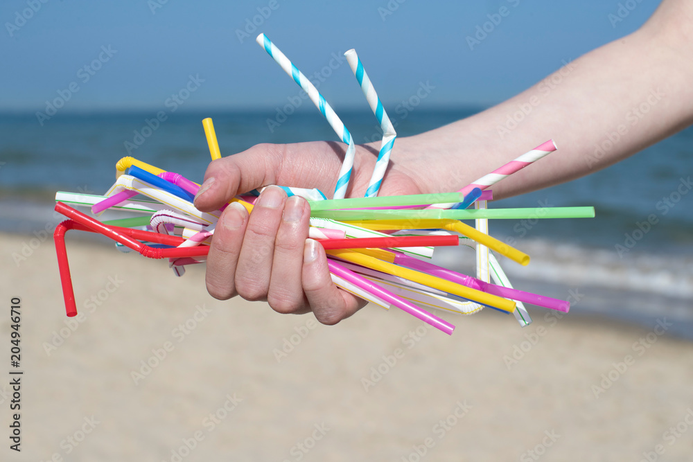 Close Up Of Hand Holding Plastic Straws Polluting Beach