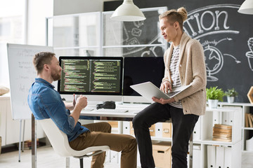 Wall Mural - Portrait of two contemporary web developers writing code for program collaborating on startup project in modern office, copy space