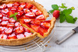 Homemade strawberry tart decorated with strawberry leaves close up
