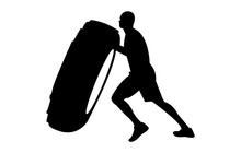 Silhouette of a young, strong man pushing a big, heavy tire