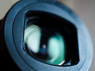 Close-up view of a camera lens from the side with a black background