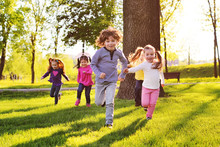 Many Young Children Smiling Running Along The Grass In The Park. Childhood, Children's Day, Vacation, Vacation, Adventure, Friendship.