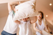 © Nebojsa - Young happy family of three playing with pillows at home