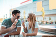 © Nebojsa - A beautiful young couple are siting on a bench and eating ice-cream on the street